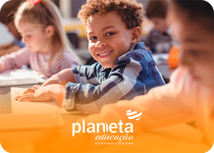 Criança em sala de aula olhando sorridente - Planneta Educação.